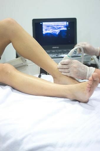 A therapist performs an x-ray on a patient's foot