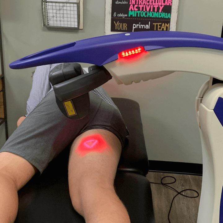 Physical therapy patient receiving laser treatment to reduce swelling and facilitate muscle healing